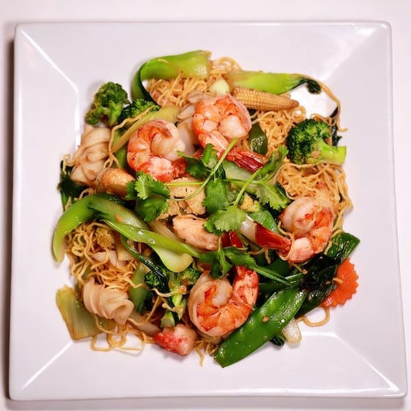Crispy egg noodles with shrimp, squid, and mixed vegetables like broccoli, bok choy, and snow peas.